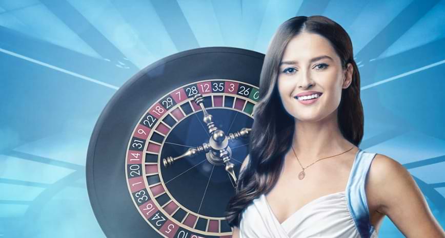 Kvindelig live dealer i hvidt toj pa roulettehjulet - NordicBet