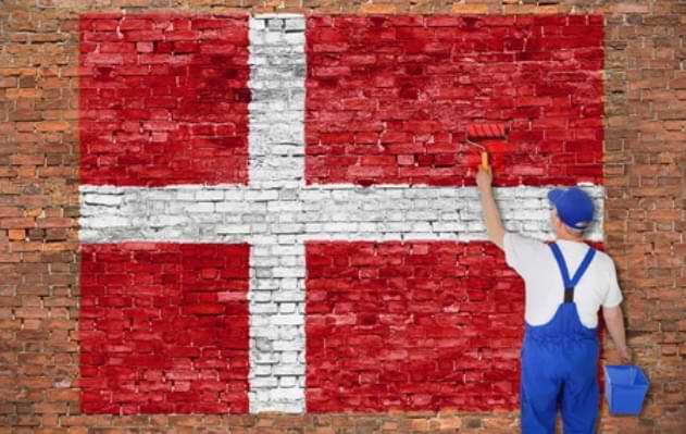 Mand i bla snedkerbukser maler det danske flag - danske licenserede casinoer